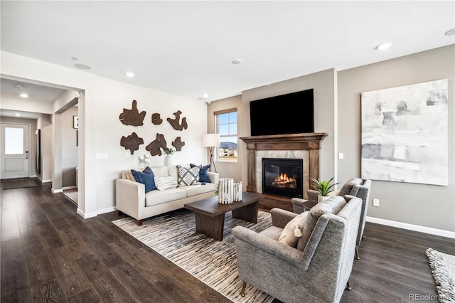 living room with dark wood-type flooring and a tiled fireplace