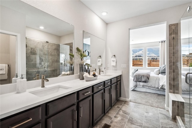 bathroom featuring a shower with door and vanity