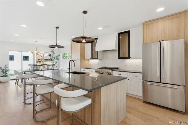 1647 N Osceola St, Denver, CO 80204 - kitchen featuring high end refrigerator, a sink, custom exhaust hood, dark countertops, and light wood-style flooring