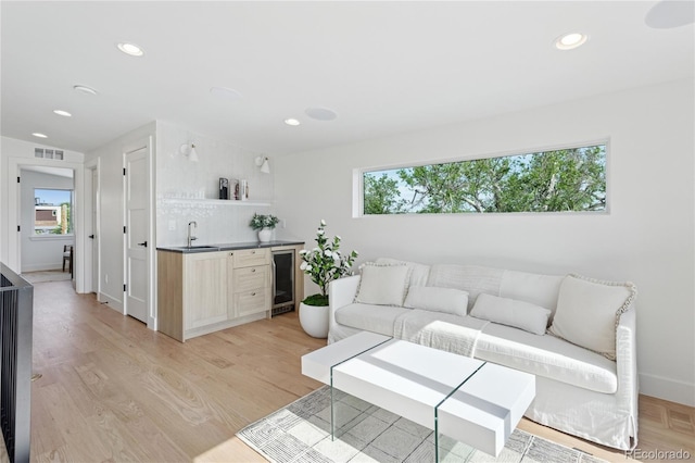 1647 N Osceola St, Denver, CO 80204 - living area featuring bar with sink, plenty of natural light, beverage cooler, recessed lighting, and light wood-style flooring