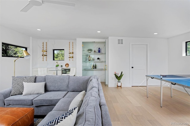 living room with recessed lighting, visible vents, baseboards, and light wood-style flooring