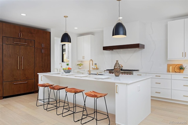 kitchen featuring a kitchen bar, light wood finished floors, and light countertops