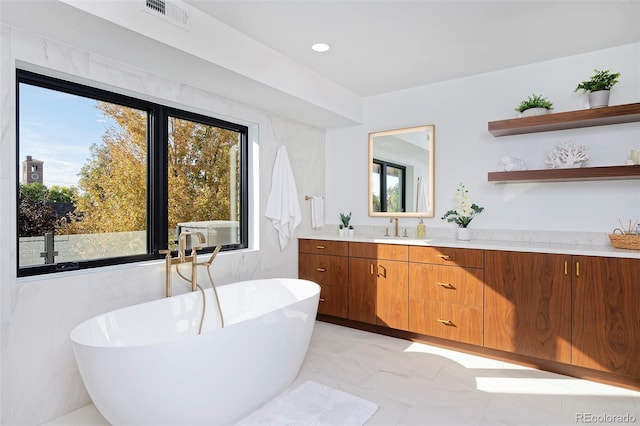 bathroom featuring vanity, visible vents, recessed lighting, a freestanding bath, and marble finish floor