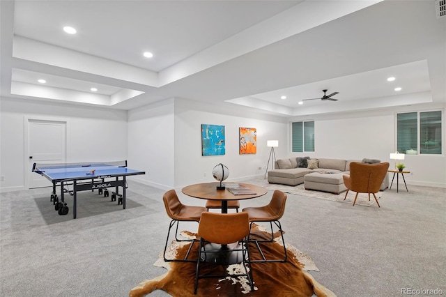 dining area with a raised ceiling and carpet flooring