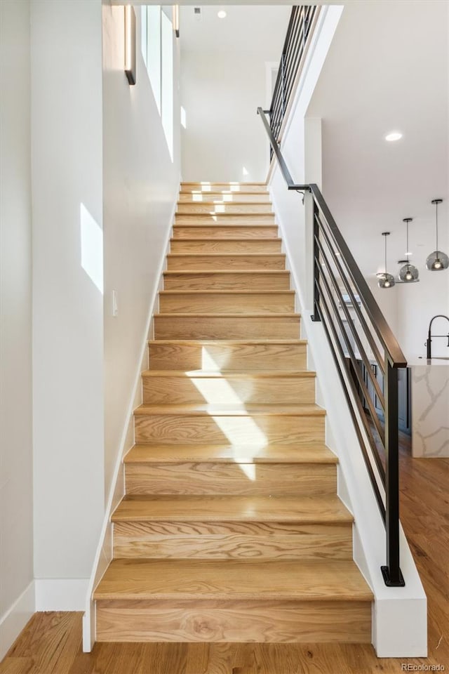 stairs featuring hardwood / wood-style floors