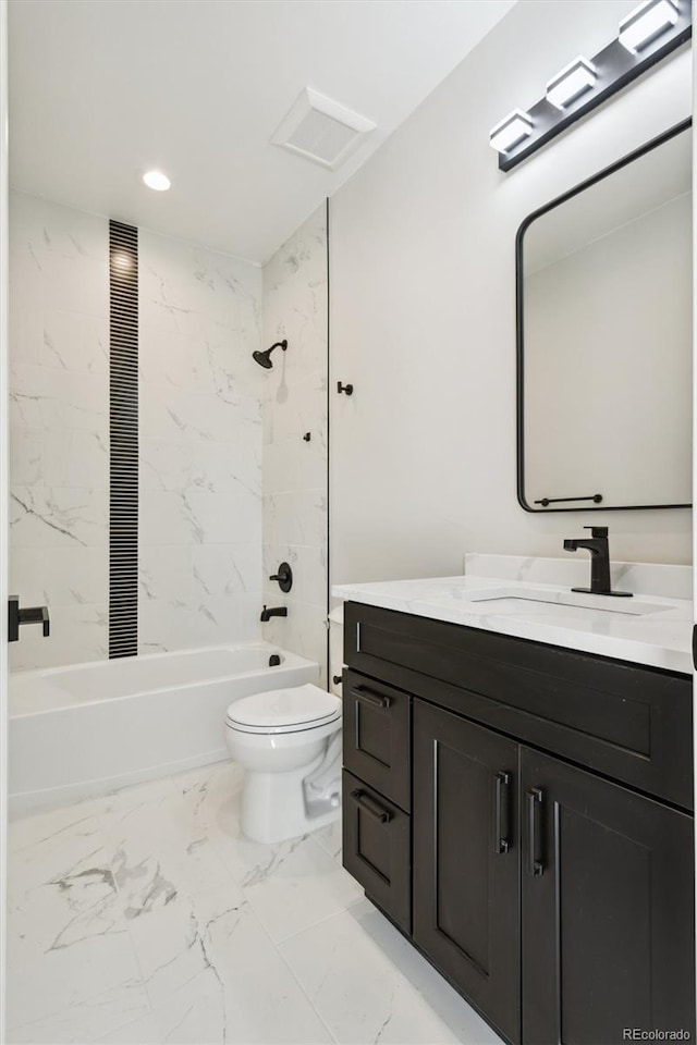 full bathroom with vanity, tiled shower / bath combo, and toilet