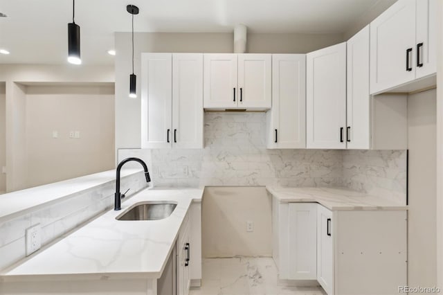 kitchen featuring sink, white cabinets, and decorative light fixtures