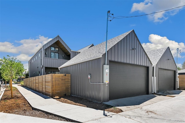 2403 S Cherokee St, Denver, CO 80223 - view of property exterior featuring roof with shingles, a detached garage, an outdoor structure, and board and batten siding