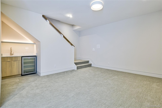 2403 S Cherokee St, Denver, CO 80223 - unfurnished living room featuring beverage cooler, bar with sink, light carpet, and stairs