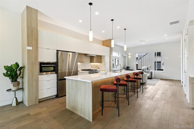2403 S Cherokee St, Denver, CO 80223 - kitchen with freestanding refrigerator, modern cabinets, light wood-style floors, a large island, and recessed lighting