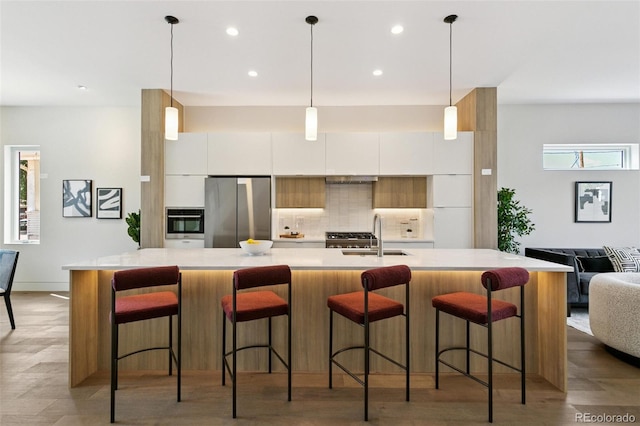 2403 S Cherokee St, Denver, CO 80223 - kitchen with appliances with stainless steel finishes, modern cabinets, white cabinetry, light countertops, and backsplash