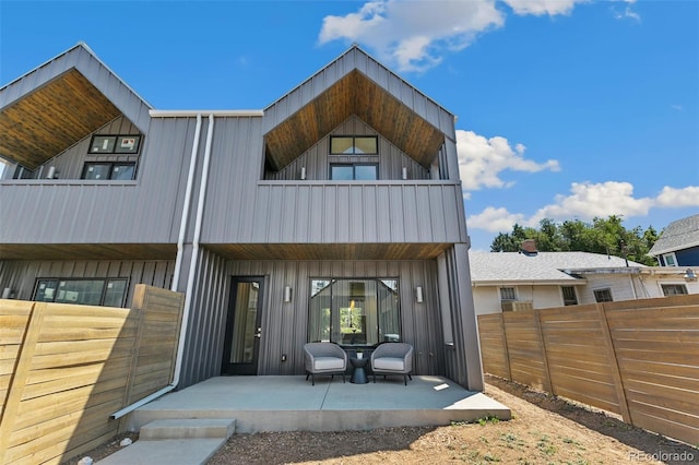2403 S Cherokee St, Denver, CO 80223 - rear view of property with a balcony, board and batten siding, and a patio
