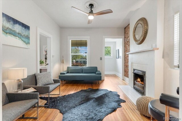 3953 Tejon St, Denver, CO 80211 - living room featuring a fireplace, wood finished floors, a ceiling fan, and baseboards