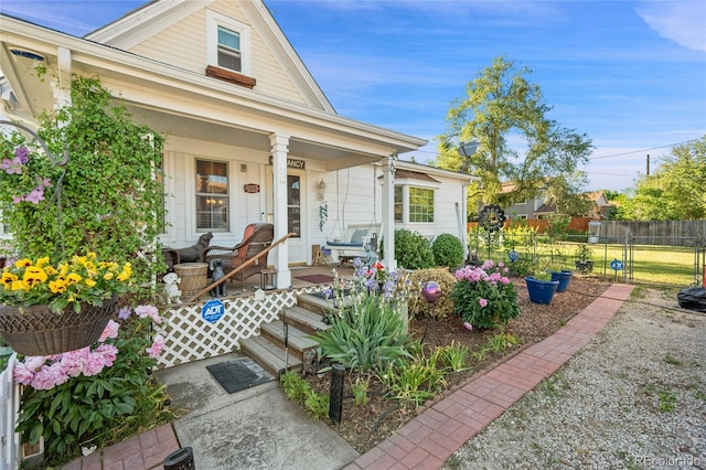 view of front of property featuring covered porch and fence