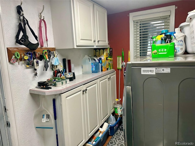 clothes washing area featuring cabinet space