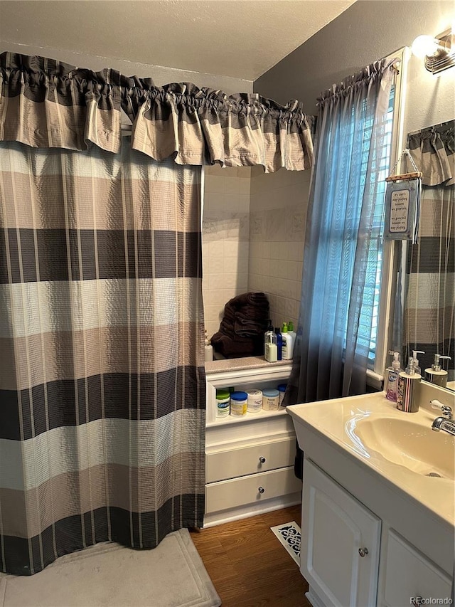 bathroom featuring vanity, curtained shower, and wood finished floors