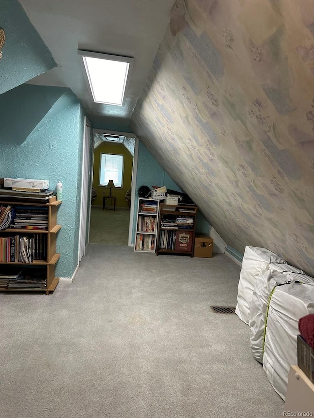 bonus room with a textured wall, carpet, and vaulted ceiling