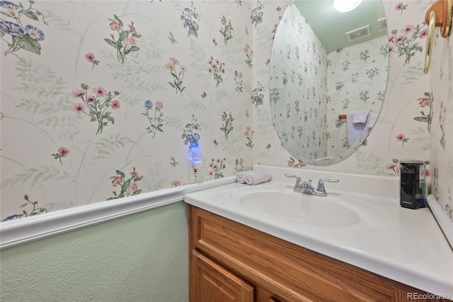 bathroom featuring wallpapered walls, visible vents, and vanity
