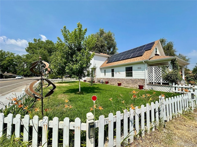 view of side of home featuring a yard, fence, solar panels, and stone siding