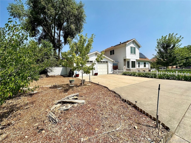 traditional-style home with a garage, fence, and driveway