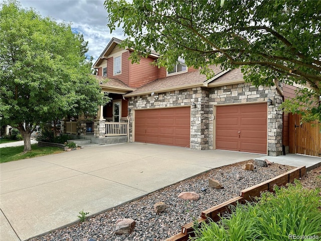 craftsman house with an attached garage, a shingled roof, stone siding, and concrete driveway