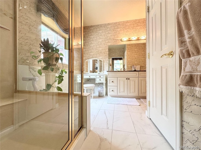bathroom with a shower with door, vanity, and marble finish floor
