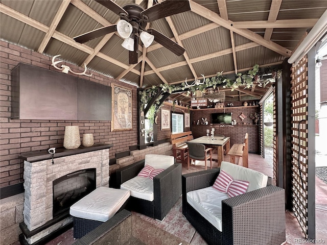view of patio / terrace with a gazebo, outdoor dining area, an outdoor stone fireplace, and a ceiling fan
