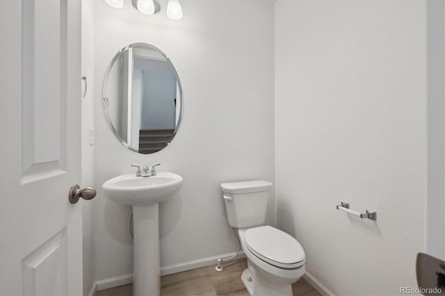 bathroom with sink, hardwood / wood-style floors, and toilet