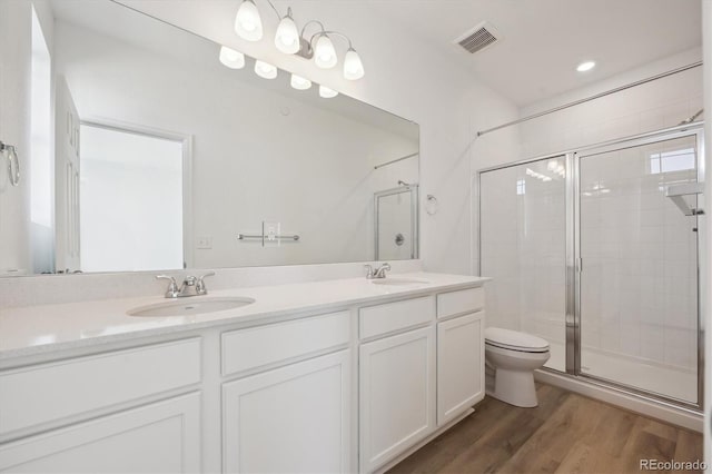 bathroom featuring vanity, hardwood / wood-style flooring, toilet, and walk in shower