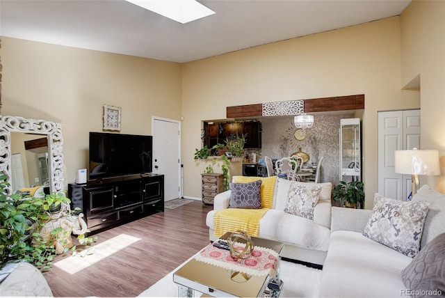 10150 E Virginia Ave Unit 18-302, Denver, CO 80247 - living area featuring a skylight, wood finished floors, and a high ceiling