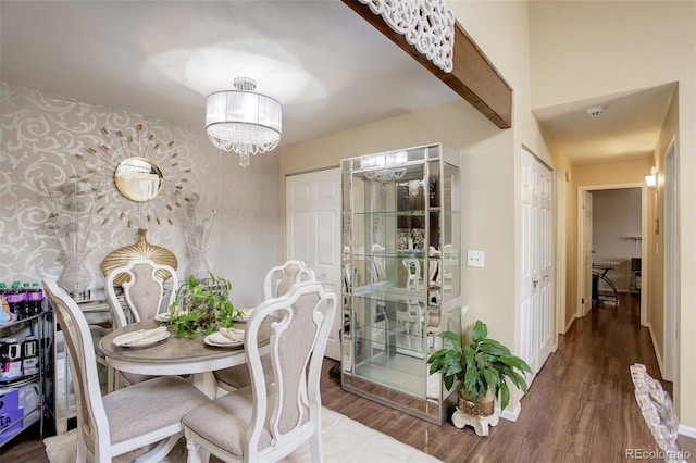10150 E Virginia Ave Unit 18-302, Denver, CO 80247 - dining space featuring a chandelier, wood finished floors, baseboards, and wallpapered walls