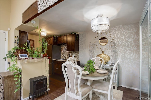 10150 E Virginia Ave Unit 18-302, Denver, CO 80247 - dining space featuring a chandelier, dark wood-style floors, and baseboards