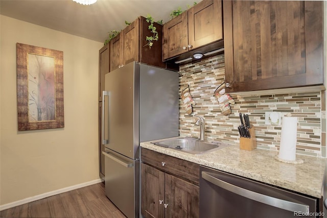 10150 E Virginia Ave Unit 18-302, Denver, CO 80247 - kitchen featuring stainless steel appliances, dark wood finished floors, tasteful backsplash, a sink, and baseboards