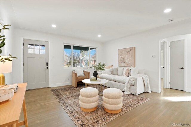 211 Newport St, Denver, CO 80220 - living area featuring light wood-type flooring, baseboards, recessed lighting, and arched walkways