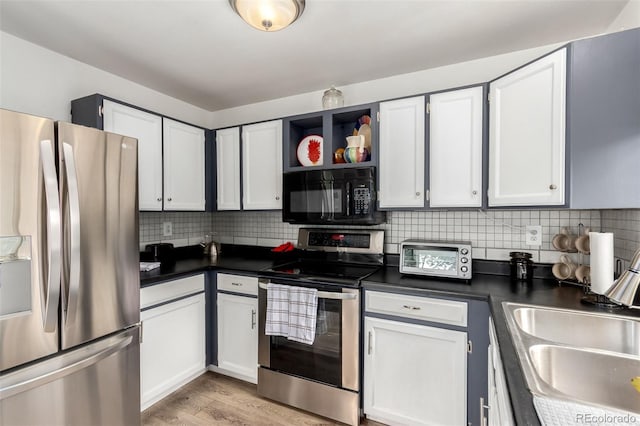 4520 E 112th Pl, Thornton, CO 80233 - kitchen featuring appliances with stainless steel finishes, a sink, dark countertops, tasteful backsplash, and light wood-type flooring