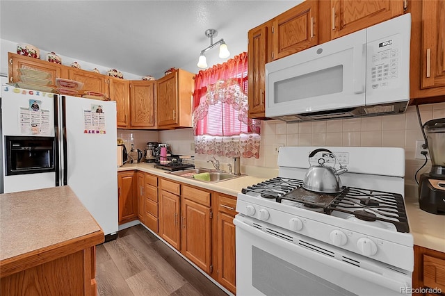 kitchen featuring sink, vaulted ceiling, dark hardwood / wood-style floors, white appliances, and decorative backsplash