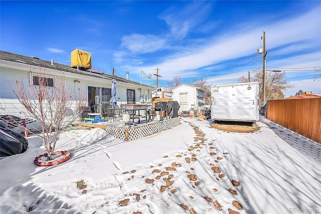 yard covered in snow with a deck