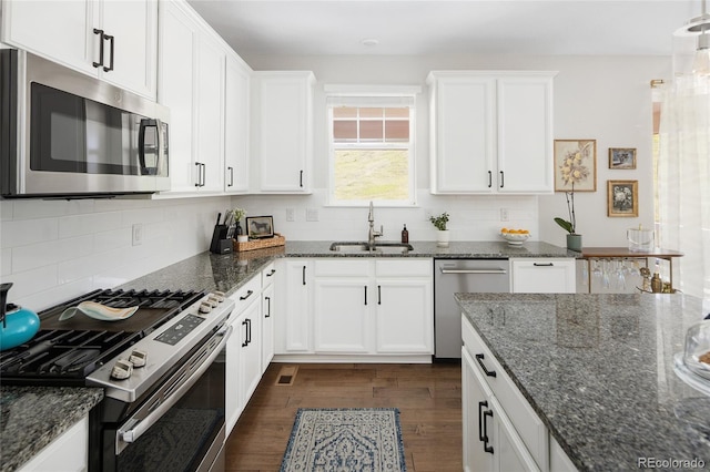 18992 W 84th Ave, Arvada, CO 80007 - kitchen with appliances with stainless steel finishes, white cabinets, decorative backsplash, and dark wood-style flooring