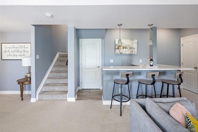18992 W 84th Ave, Arvada, CO 80007 - kitchen featuring a kitchen breakfast bar, light countertops, light colored carpet, hanging light fixtures, and a kitchen island