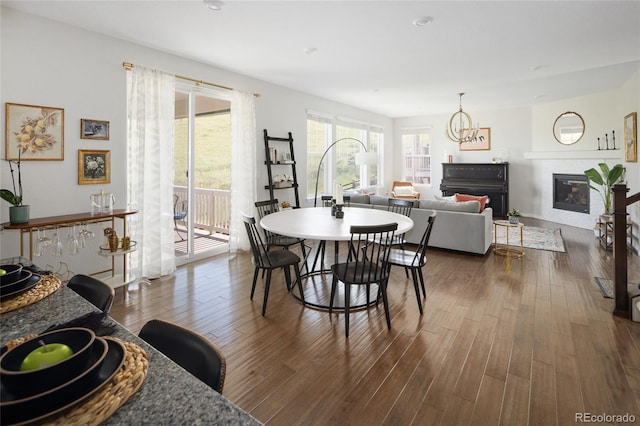 18992 W 84th Ave, Arvada, CO 80007 - dining area with a glass covered fireplace, dark wood-type flooring, and a chandelier
