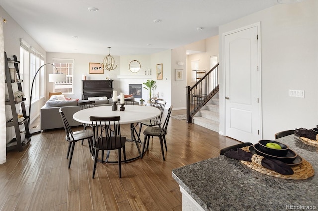 18992 W 84th Ave, Arvada, CO 80007 - dining space with stairway, a glass covered fireplace, and dark wood finished floors