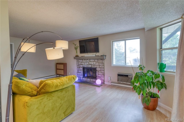 17595 E Mansfield Ave Unit 1331L, Aurora, CO 80013 - living room featuring a textured ceiling, wood finished floors, a fireplace, baseboards, and a baseboard radiator
