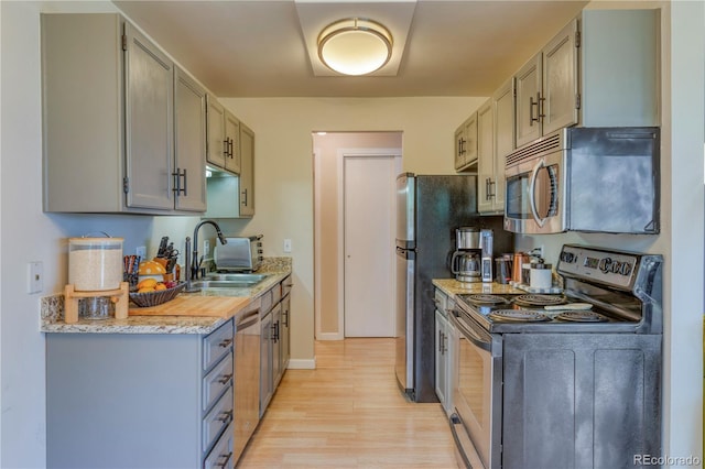 17595 E Mansfield Ave Unit 1331L, Aurora, CO 80013 - kitchen featuring appliances with stainless steel finishes, a sink, light wood-type flooring, and gray cabinetry
