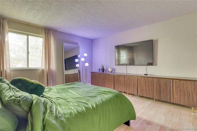 17595 E Mansfield Ave Unit 1331L, Aurora, CO 80013 - bedroom with light wood-style floors and a textured ceiling