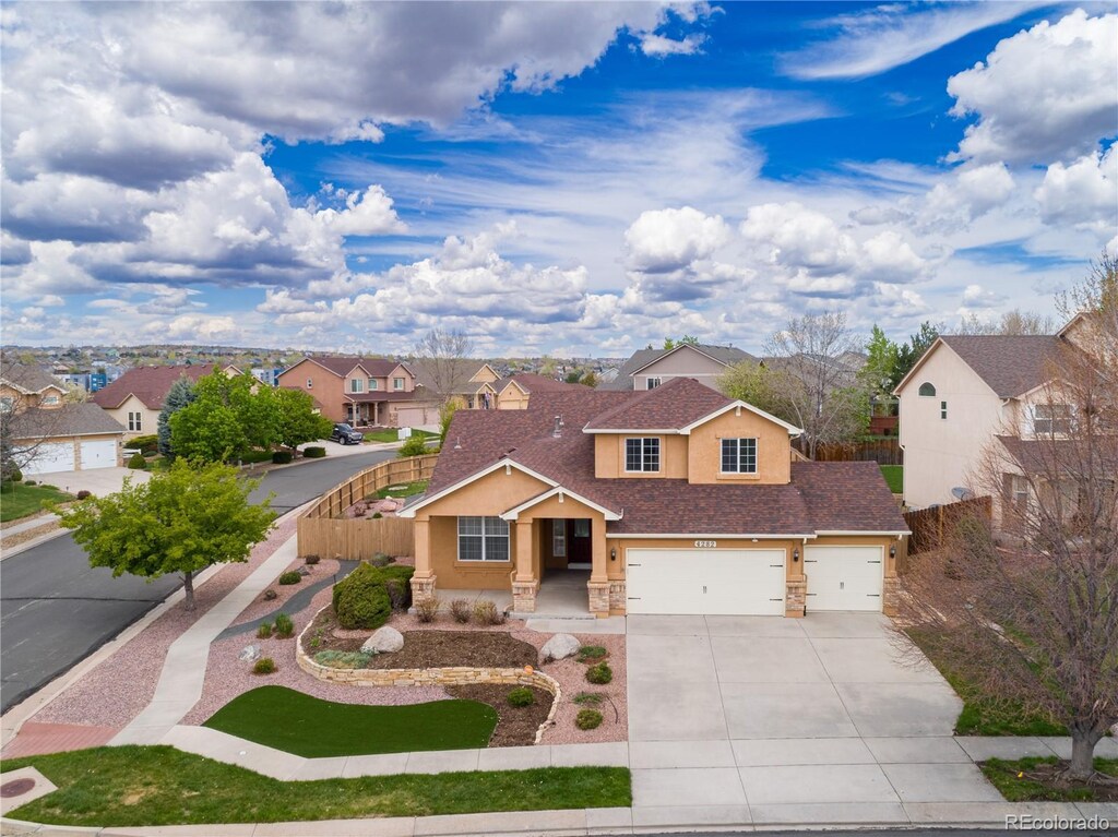 4282 Thornbury Way, Colorado Springs, CO 80922 - traditional-style house featuring a residential view, stucco siding, stone siding, concrete driveway, and fence