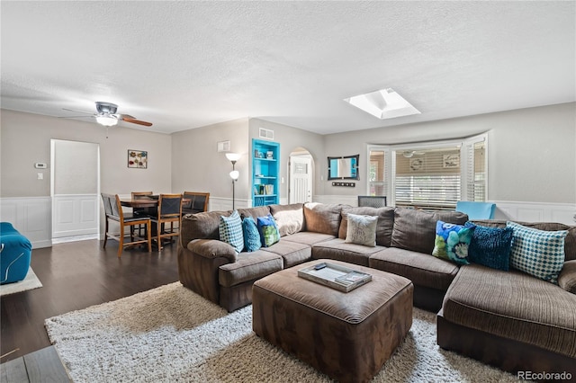 3625 Chase St, Wheat Ridge, CO 80212 - living area with a textured ceiling, wainscoting, wood finished floors, a skylight, and arched walkways
