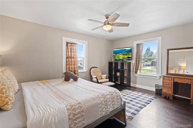 3625 Chase St, Wheat Ridge, CO 80212 - bedroom with multiple windows, dark wood-style floors, a textured ceiling, baseboards, and ceiling fan