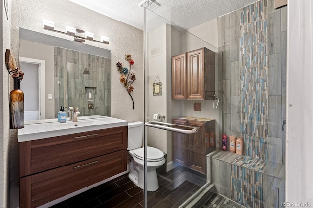 3625 Chase St, Wheat Ridge, CO 80212 - bathroom featuring vanity, a textured ceiling, toilet, a textured wall, and tiled shower