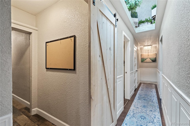3625 Chase St, Wheat Ridge, CO 80212 - corridor with a barn door, a textured wall, wainscoting, and a decorative wall