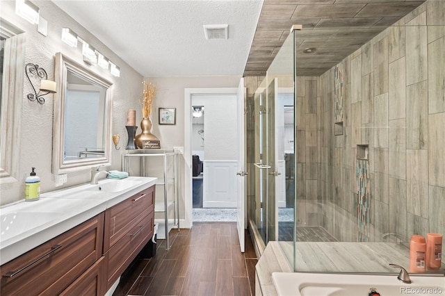 3625 Chase St, Wheat Ridge, CO 80212 - full bathroom with double vanity, a shower stall, a bath, wood finish floors, and a textured ceiling